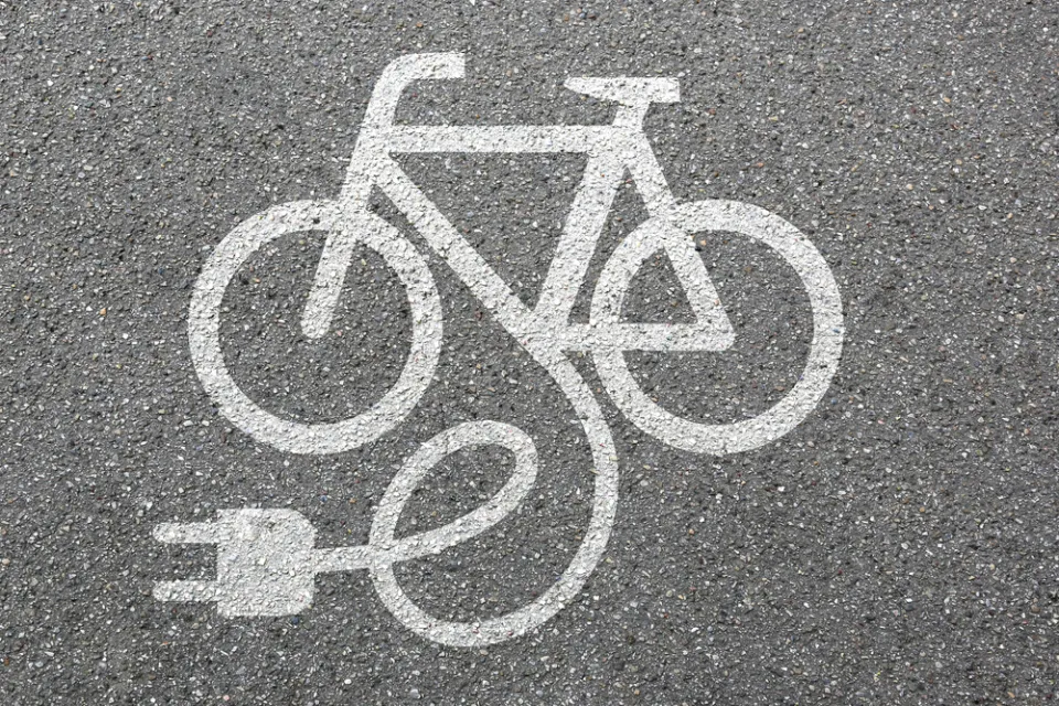 White electric bike logo on asphalt